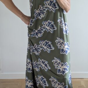 Vestido estampado de flores turquesa con fondo verde.