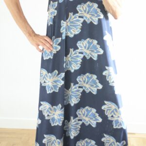 Vestido estampado de flores turquesa con fondo azul.