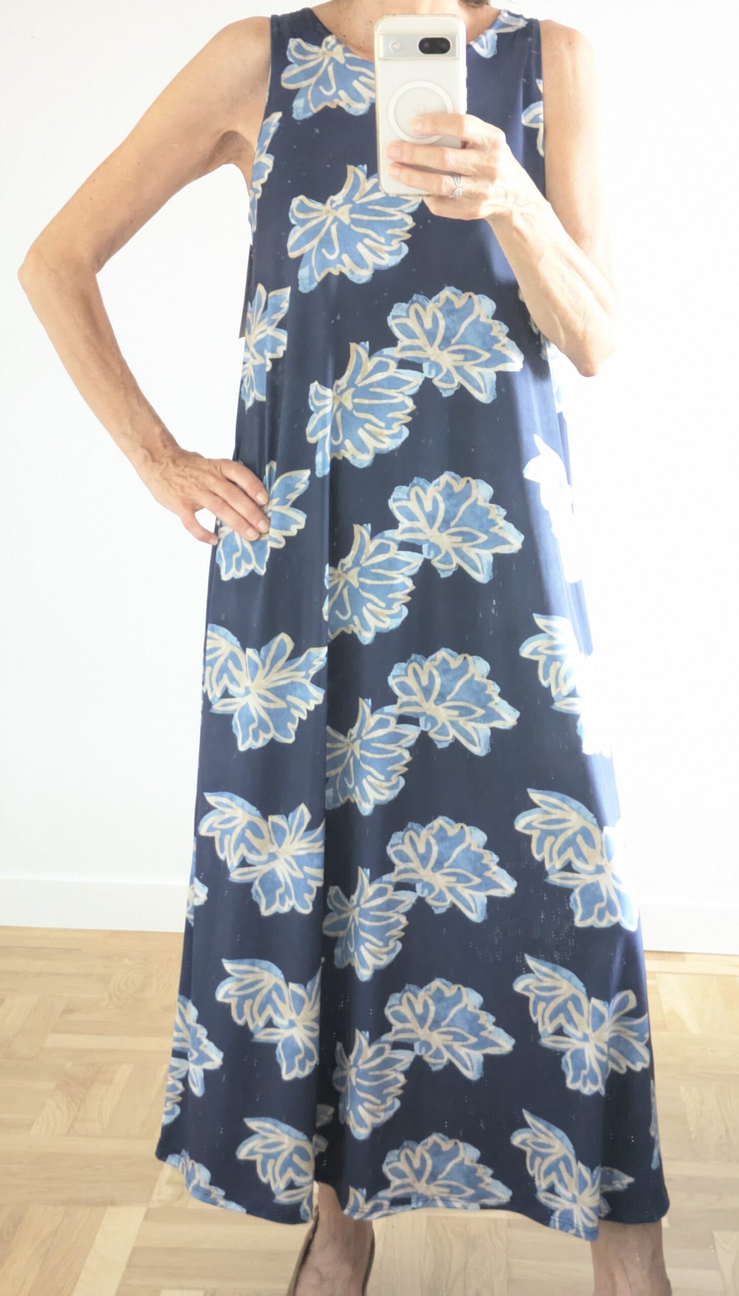 Vestido estampado de flores turquesa con fondo azul.